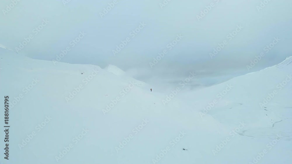 Mountain Climber on a Snowy Hilltop Climbing Towards the Summit Mountain Climber on a Snowy Hilltop Climbing Towards the Summit
