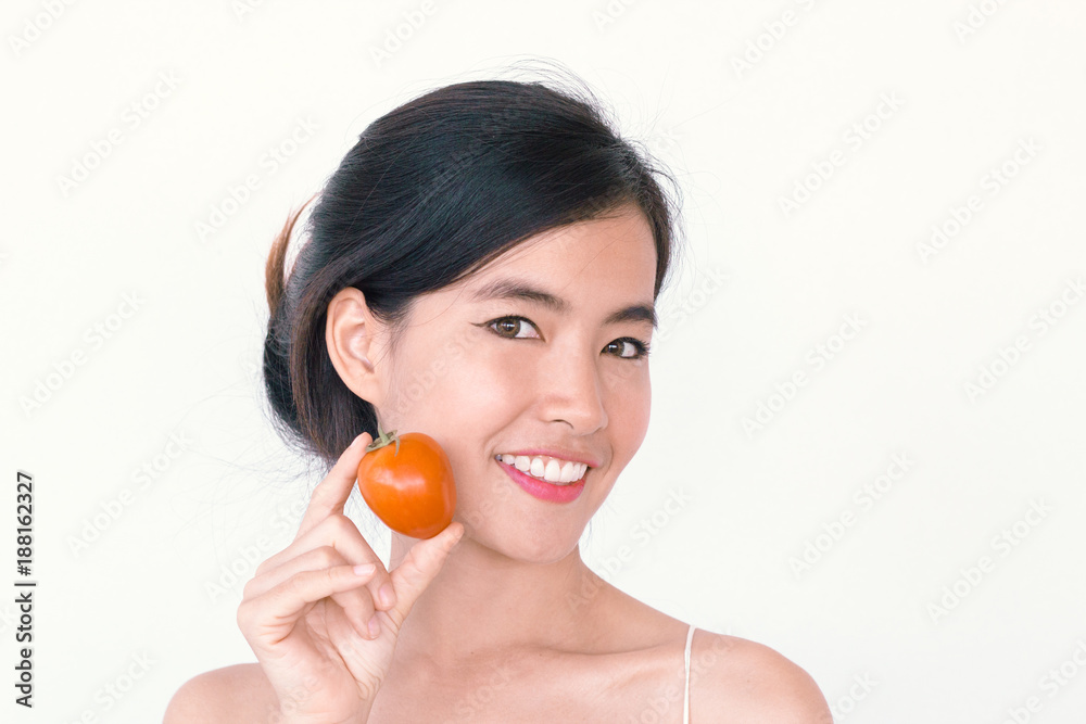 Beauty lycopene Skincare concept- Young Asian woman after shower  smiling holding red tomato