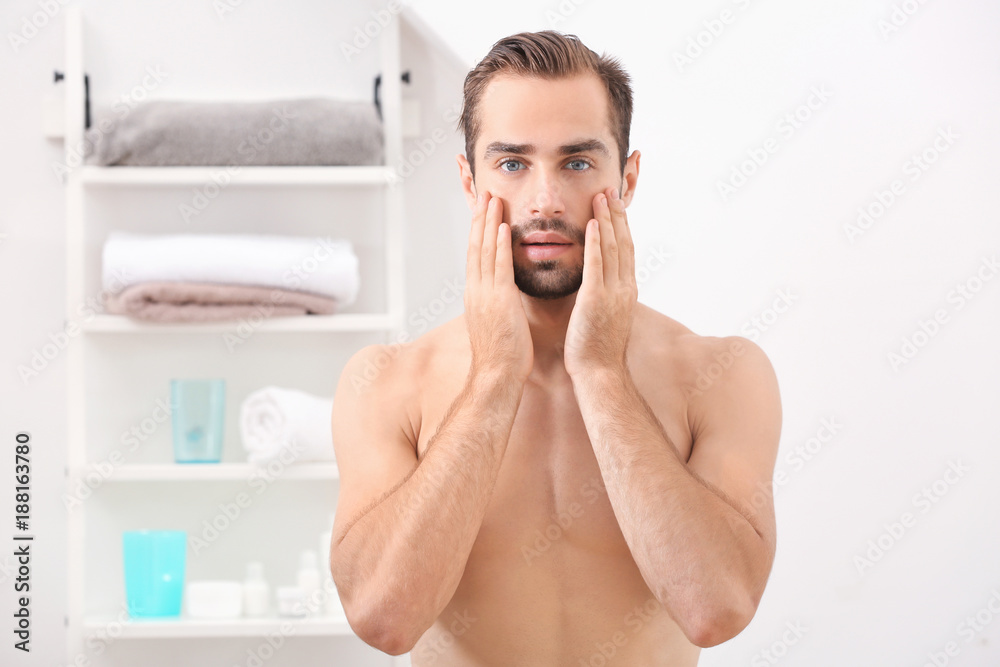 Young handsome man standing in bathroom Young handsome man standing in bathroom