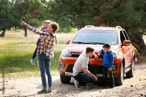 Happy family near modern ca...