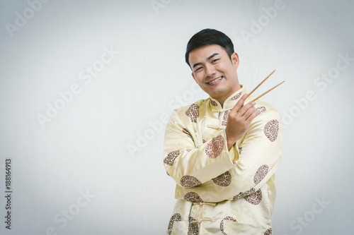 Young Chinese man holding chopsticks