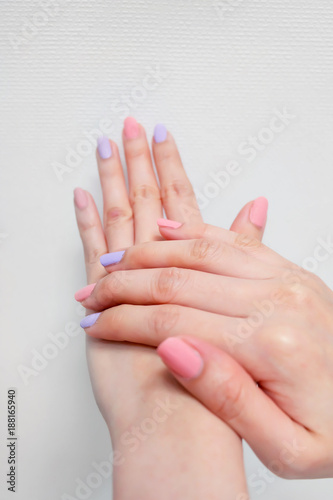 Close Up Nail Polish Manicure. Beautiful Woman is Hands on Pink and Violet Pastel on White Background Great for Any Use.