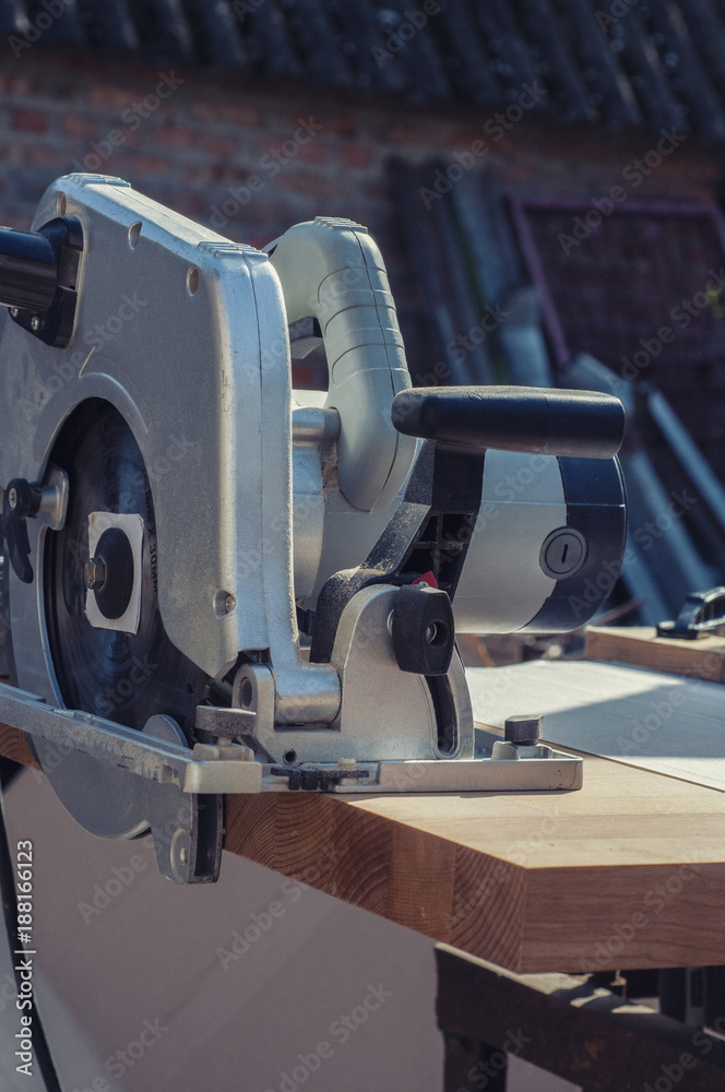 Fototapeta premium Close up electric saw to sawing wood board, solf focus.