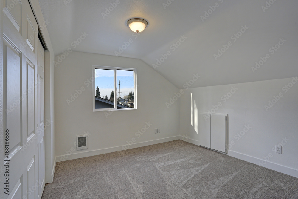 Empty bedroom interior with vaulted ceiling on the upper floor. Empty bedroom interior with vaulted ceiling on the upper floor.