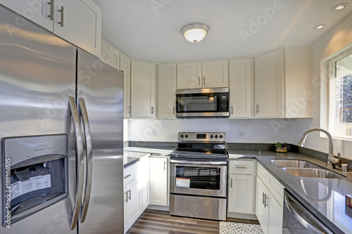 Light filled home interior features small compact kitchen