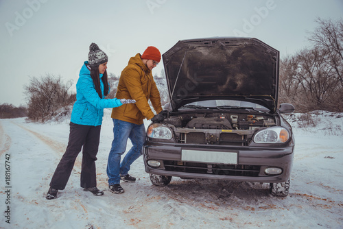 couple on the road with broken car photo