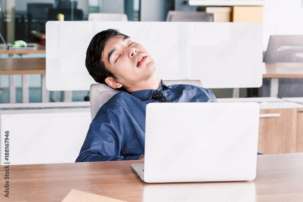 Tired businessman sleeping with laptop on the table at office Tired businessman sleeping with laptop on the table at office