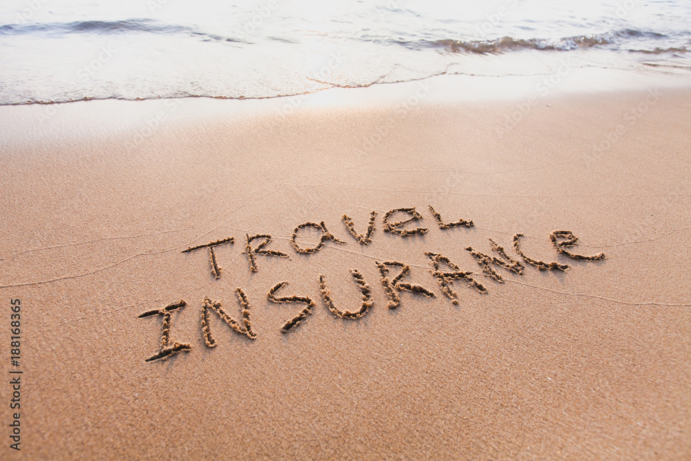 Fototapeta premium travel insurance concept, text words written on the sand