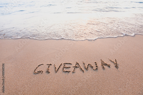 giveaway concept, word message written on the sand