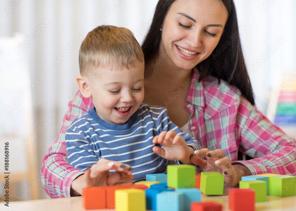 Child boy together with mother playing toys Child boy together with mother playing toys
