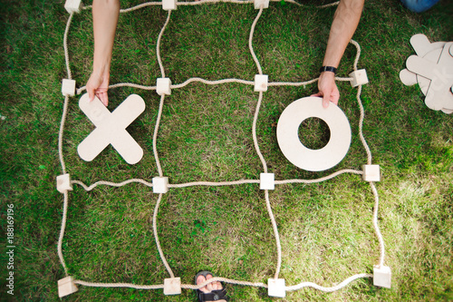 Friends playing tic-tac-toe on green grass