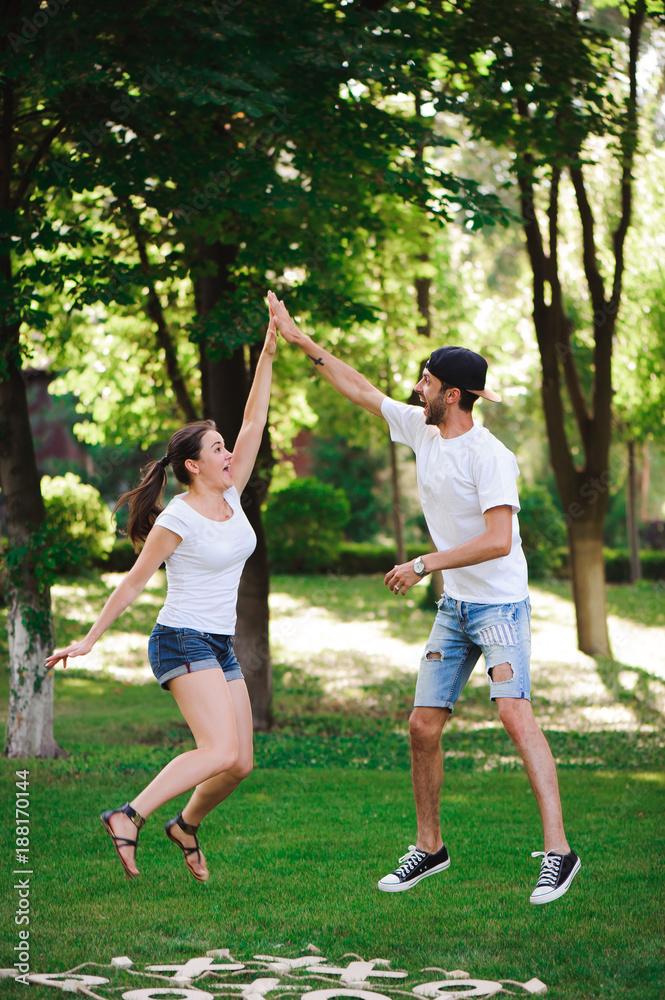 A young couple celebrate victory playing tic-tac-toe in the park A young couple celebrate victory playing tic-tac-toe in the park