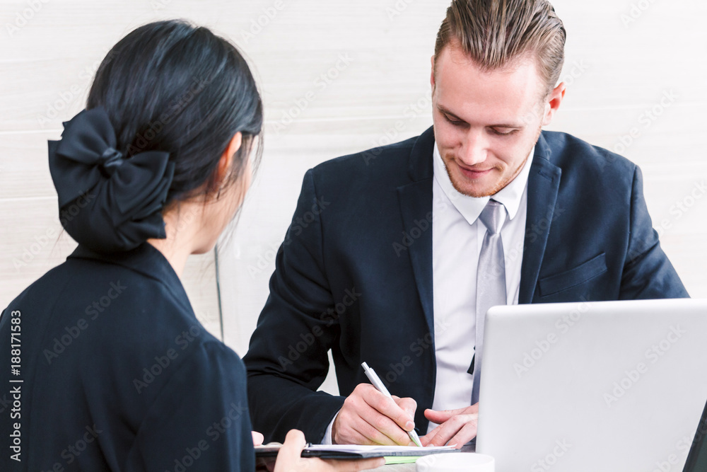Businesswoman showing to the new contract for businessman signing contract document at office Businesswoman showing to the new contract for businessman signing contract document at office