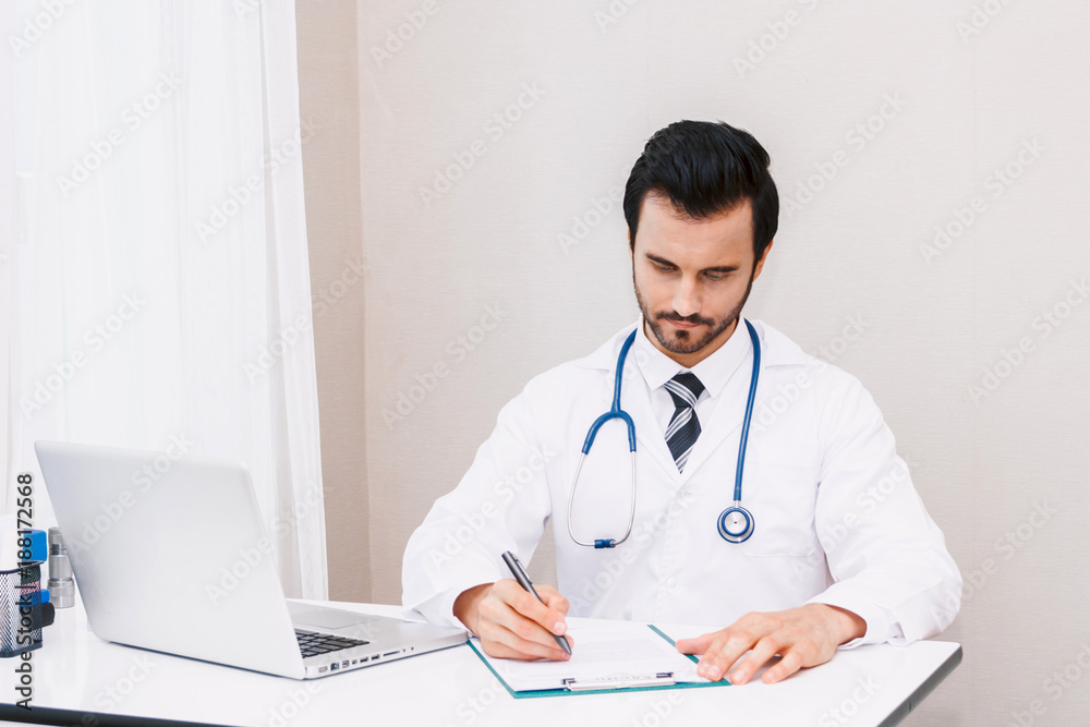 Doctor with stethoscope working and writing on paperwork in hospital.healthcare and medicine Doctor with stethoscope working and writing on paperwork in hospital.healthcare and medicine
