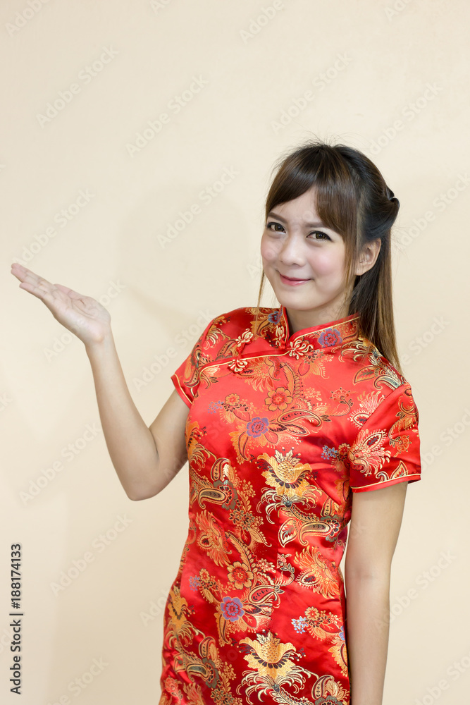 Asian woman greeting in traditional Chinese or cheongsam with hand lift welcome expression and lucky in chinese new year celebration in red golden style Asian woman greeting in traditional Chinese or cheongsam with hand lift welcome expression and lucky in chinese new year celebration in red golden style