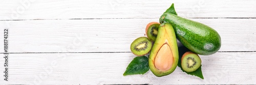 Avocado and kiwi on a wooden background. Top view. Free space for your text.