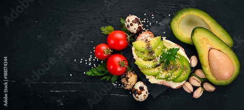 Sandwich with avocado, butter and chia seeds. On a wooden background. Top view. Free space for your text.