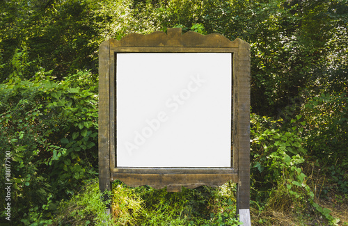A blank white board in a forest for information ,sign for advertising