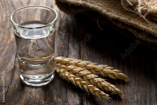 Leinwand Poster German hard liquor Korn Schnapps in shot glass with wheat ears
