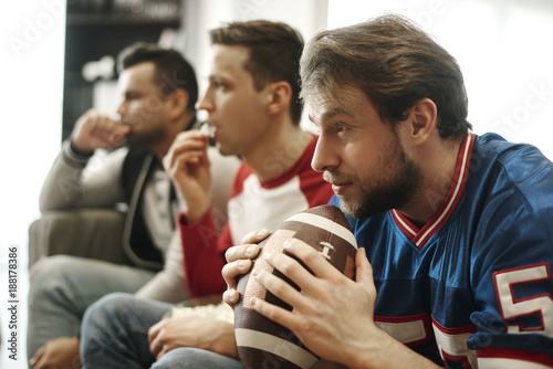 Photos Focused watching football game at home