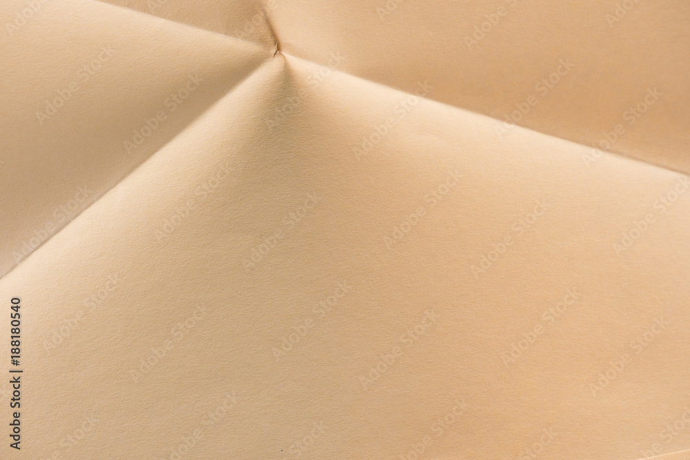 close-up shot of folded biege color paper close-up shot of folded biege color paper
