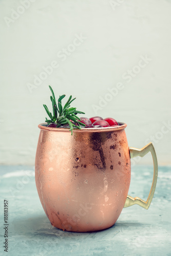 Photography Cold christmas Moscow Mule cocktail in copper mug on the rustic background