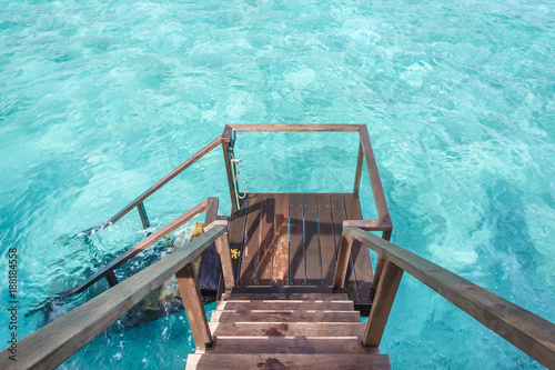 Stair down to crystal clear ocean from water villa private balcony