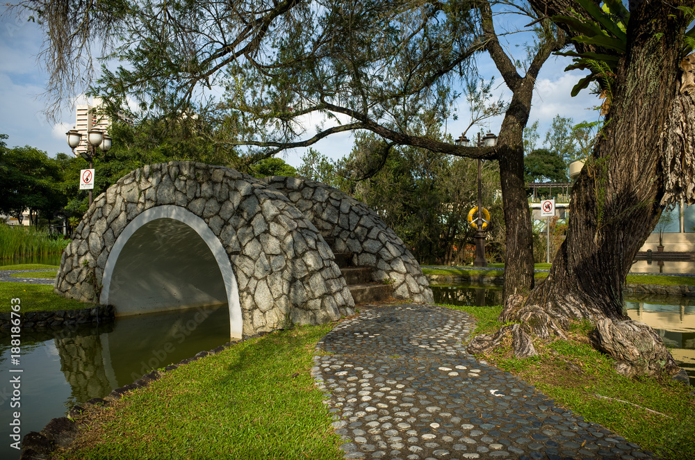 A stone Bridge at Toa Payoh Town Park provides a walkway over a pond.