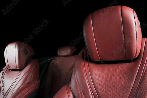 Modern Luxury car inside. Interior of prestige modern car. Comfortable leather seats. Red perforated leather cockpit with isolated Black background. Modern car interior details © Aleksei