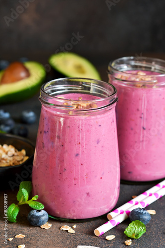 Organiik drink. Smoothies of yogurt with avocado, honey, blueberries and granola on a dark background. Easy snack.