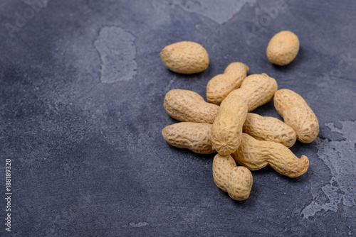 Closeup unpeeled peanuts on stone background
