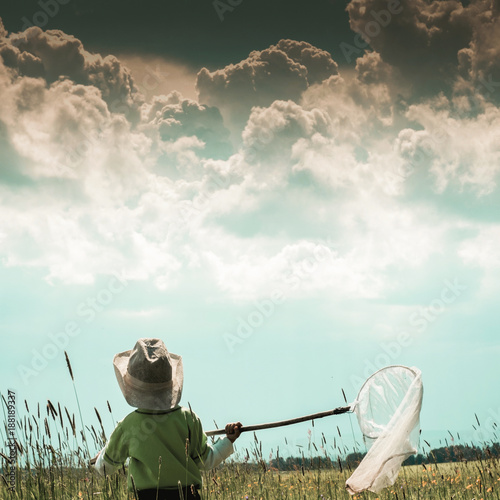 Boy with butterfly net. Ural landscape. A boy in the garden is catching butterflies.