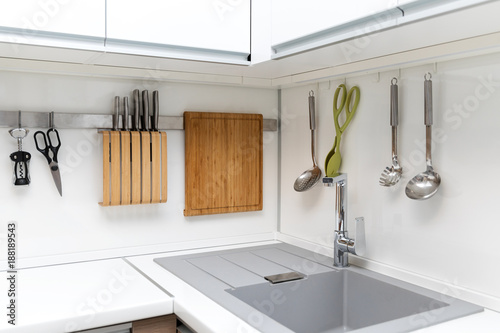 white glossy kitchen interior design with hanging utensils