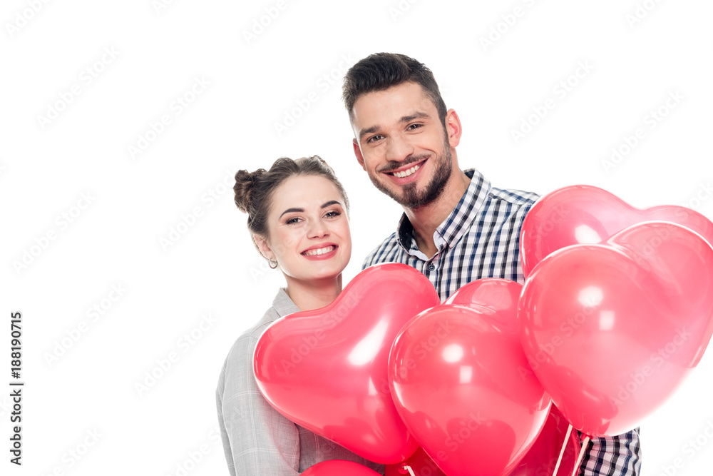smiling couple holding heart shaped balloons isolated on white, valentines day concept smiling couple holding heart shaped balloons isolated on white, valentines day concept