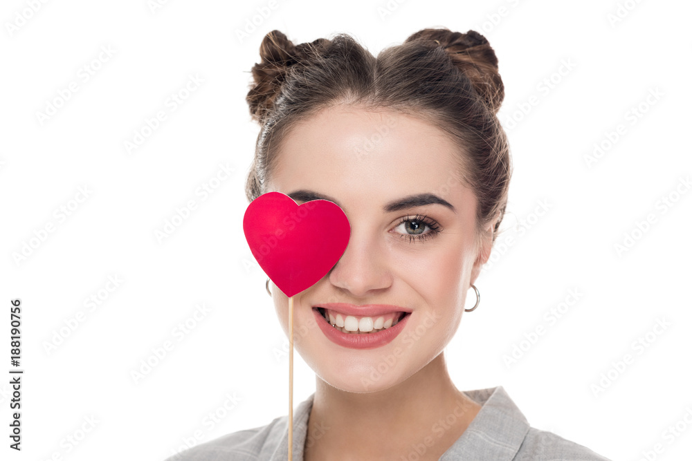 smiling girl covering eye with paper heart isolated on white, valentines day concept smiling girl covering eye with paper heart isolated on white, valentines day concept