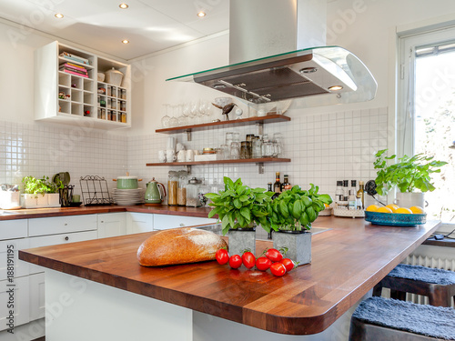 tomatoes, basil and fresh brad on the counter top with kitchen in the background