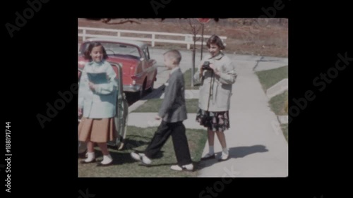 Kids take pictures in front of antique cars
