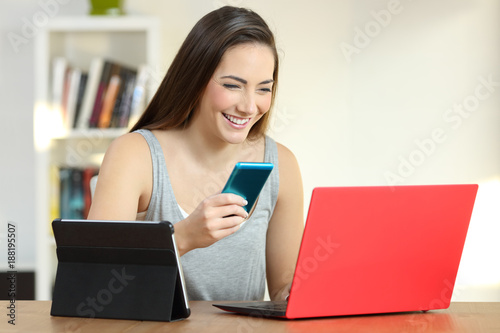 Smiley girl using multiple devices at home
