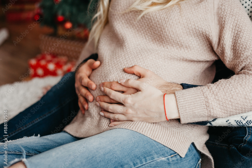 pregnant woman and her partner hold on to the belly