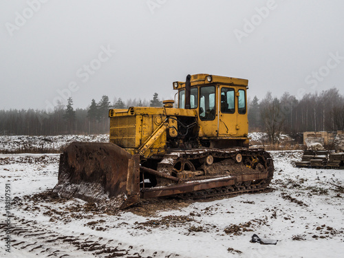 old yellow bulldozer at winter in workplace