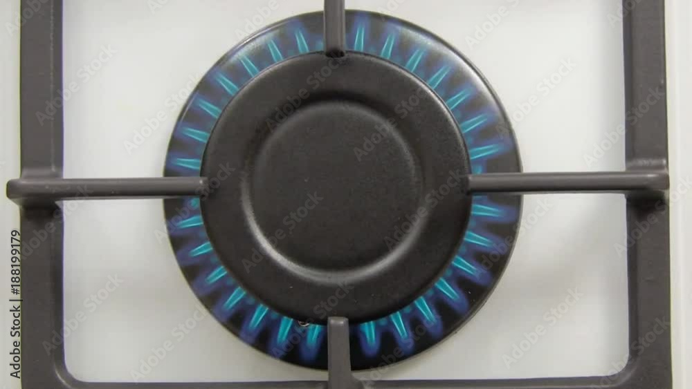 Natural gas inflammation in stove burner, close up view. gas burning from a kitchen gas stove Natural gas inflammation in stove burner, close up view. gas burning from a kitchen gas stove