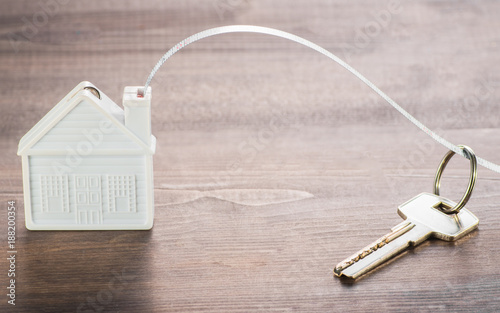 The layout of the house and key on a wooden Board. photo