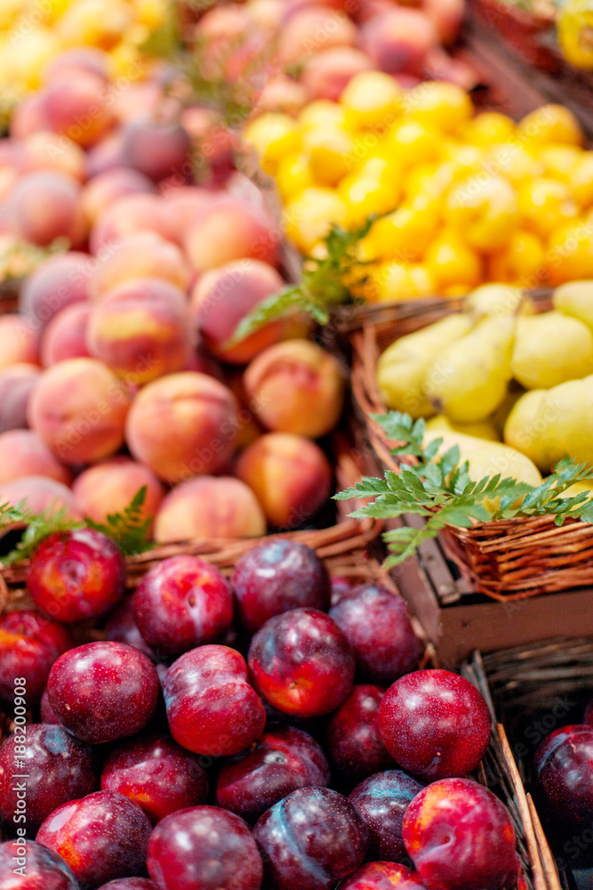 Red ripe organic plums in the market. Whole fresh plums harvest. Food background Red ripe organic plums in the market. Whole fresh plums harvest. Food background
