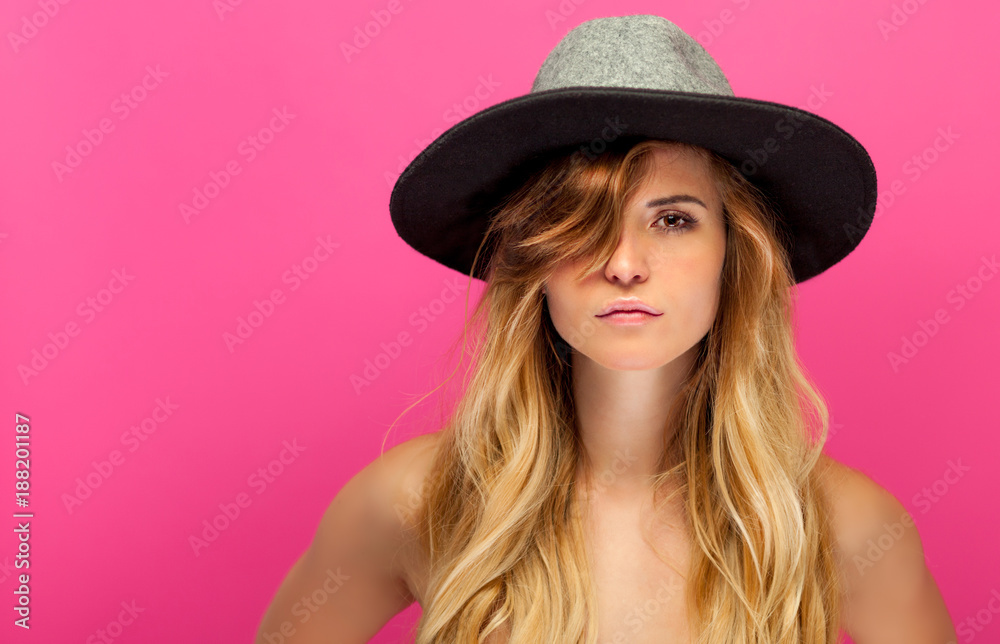 Beautiful young woman with hat and long blonde hair on pink background Beautiful young woman with hat and long blonde hair on pink background