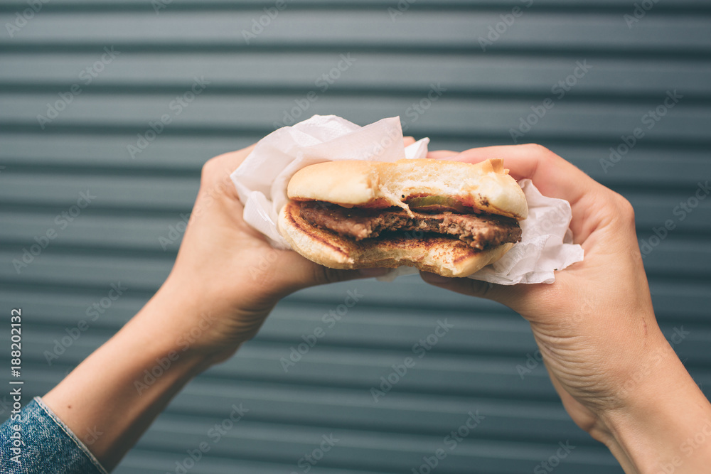 Eating hamburger. Delicious hamburger in the hands. Fastfood meal. Eating hamburger. Delicious hamburger in the hands. Fastfood meal.