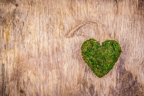 Green heart on wooden background