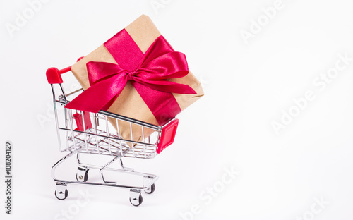 Shopping cart with a large gift box. Discounts and gifts. Copy space