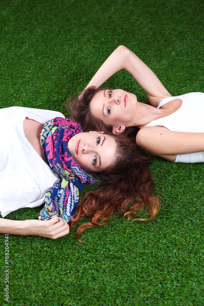 Two pretty girls lying on the fresh green grass Two pretty girls lying on the fresh green grass