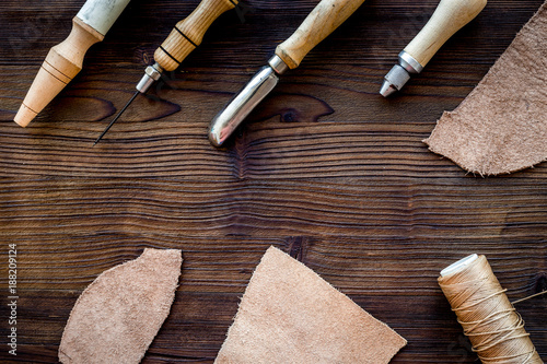 Leather craft accessories. Tools and matherials on dark wooden b photo