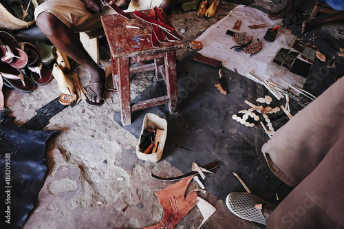 Men working into the shoes shop. In this place, they produce a typical kenyan shoes with leather and other materials.  